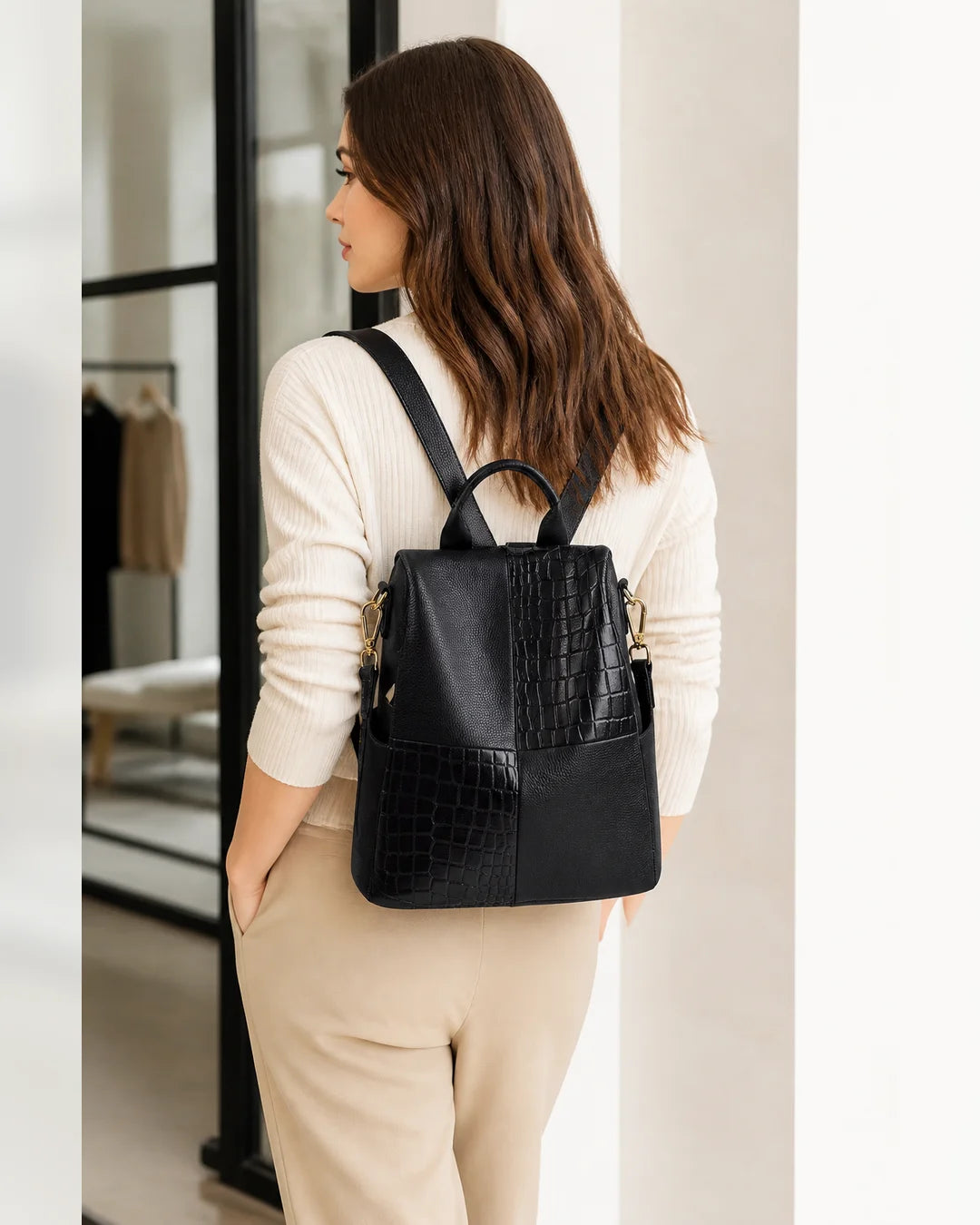 Mulher usando a mochila feminina de couro preta Elvienne nas costas, destacando tamanho, caimento e estilo no uso diário.