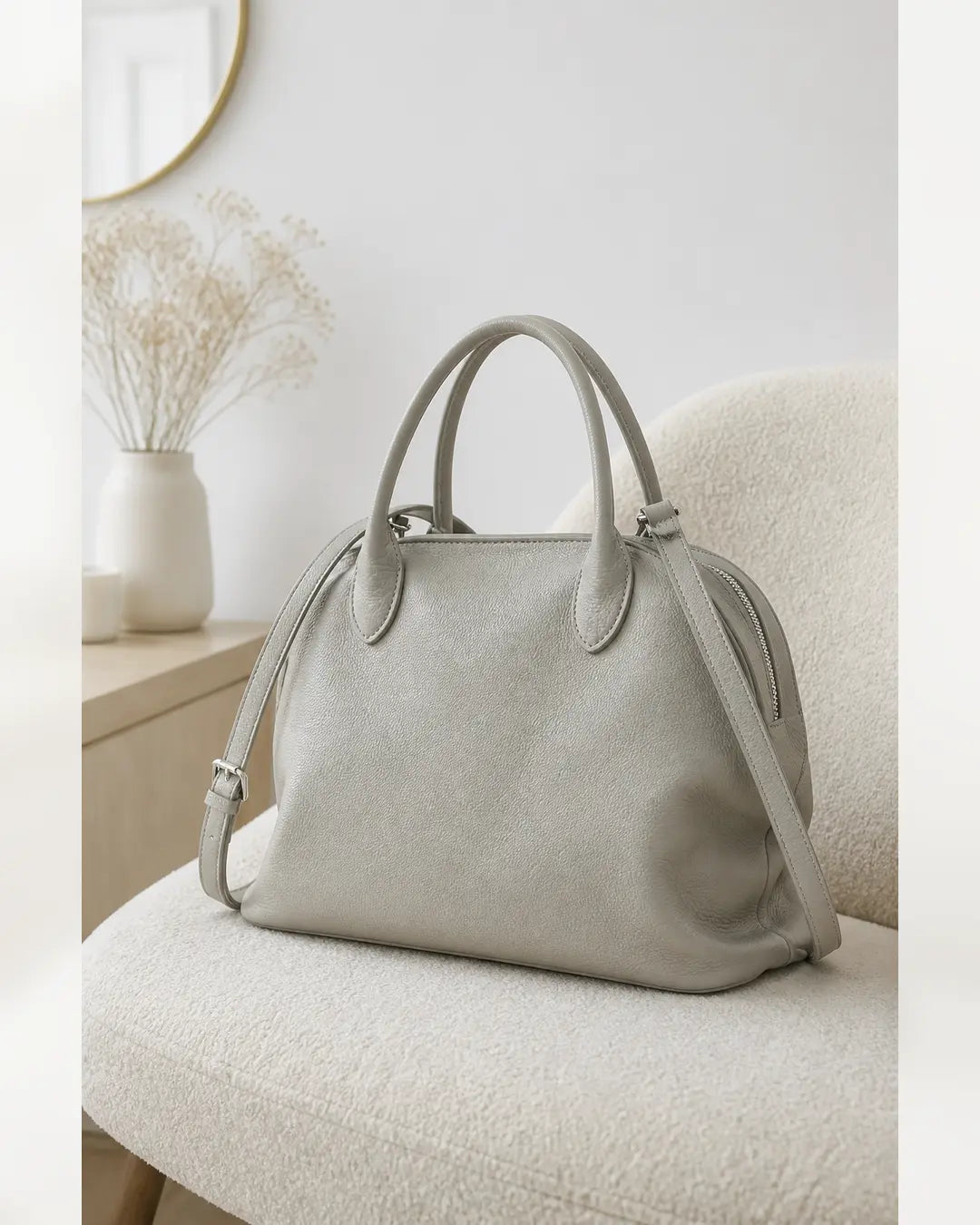 Bolsa feminina de couro cinza claro Vivienne em ambiente claro, com design elegante e alça transversal.