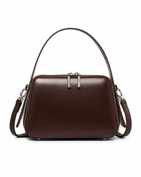 Bolsa feminina de couro marrom Elyra, vista frontal, com alça de mão, alça transversal removível, ferragens prateadas e fechamento superior em zíper.
