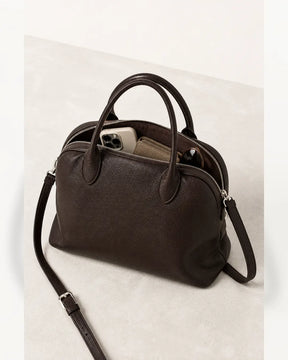 Bolsa feminina de couro marrom Vivienne aberta, mostrando espaço interno para celular, carteira e óculos.