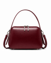 Bolsa feminina de couro marsala Elyra, vista frontal, com alça de mão, alça transversal removível, ferragens prateadas e fechamento superior em zíper.