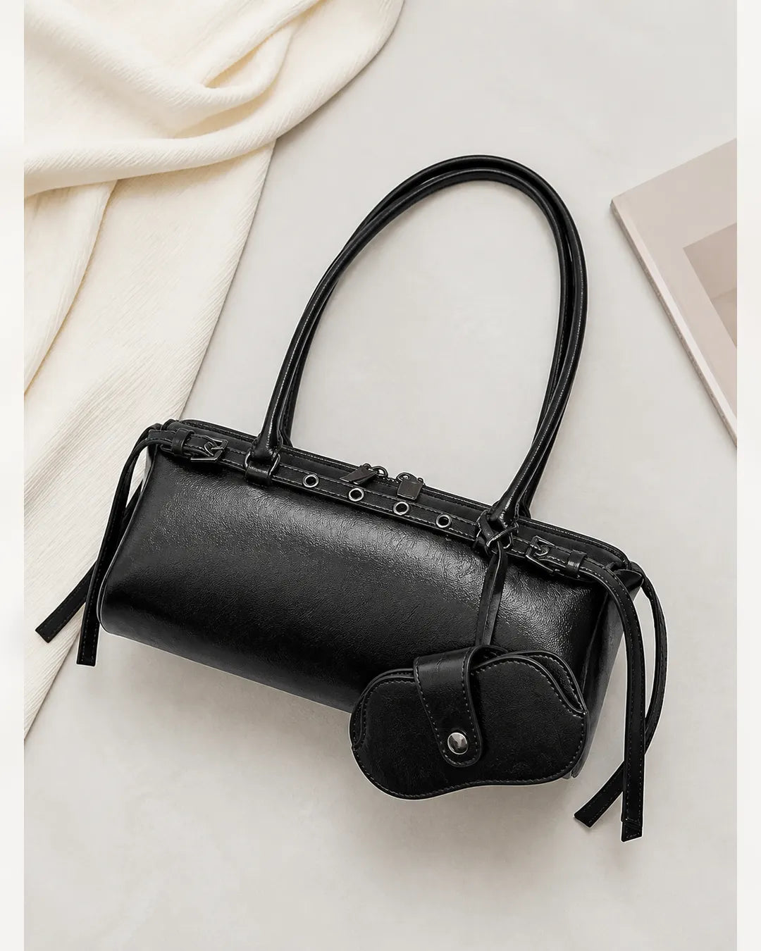 Bolsa feminina de couro preta Celinne em montagem com vista frontal e closes dos detalhes, mostrando o acabamento texturizado, os metais, as alças longas e o porta-óculos combinando.
