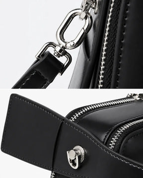Detalhes da bolsa feminina de couro preta Elyra, mostrando ferragens prateadas da alça removível, zíper e acabamento lateral em couro.