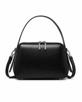 Bolsa feminina de couro preta Elyra, vista frontal, com alça de mão, alça transversal removível, ferragens prateadas e fechamento superior em zíper.