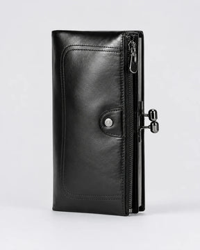 Carteira feminina de couro preta Delphine em vista frontal, com acabamento elegante, costuras aparentes, bolso com zíper e fecho metálico lateral.

