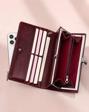 Carteira feminina de couro vermelha Delphine aberta, mostrando compartimentos internos para cartões, notas, celular e bolso com zíper para moedas.
