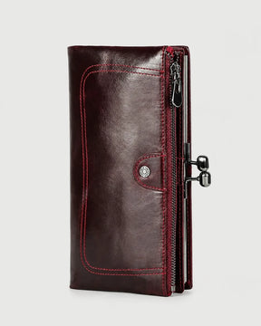 Carteira feminina de couro vermelha Delphine em vista frontal, com acabamento elegante, costuras aparentes, bolso com zíper e fecho metálico lateral.
