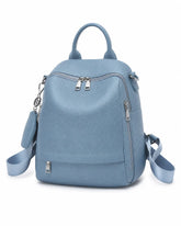 Mochila feminina de couro azul Serelle em vista frontal angulada, com alça de mão, bolsos externos com zíper e detalhe de acessório lateral.
