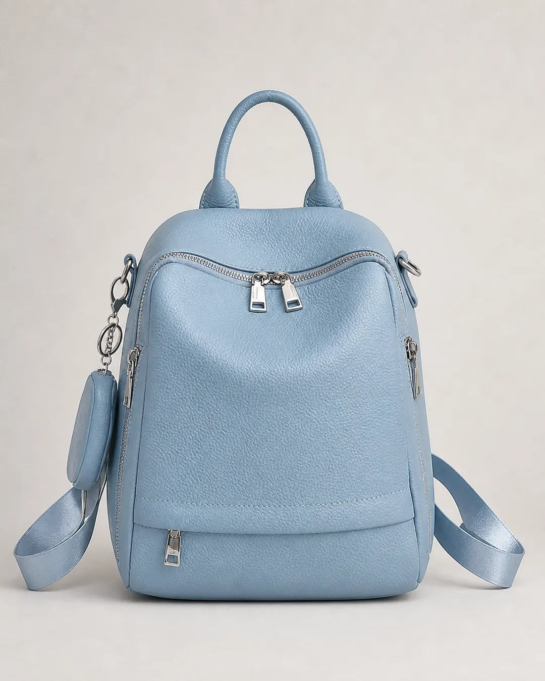 Mochila feminina de couro azul Serelle em vista frontal, destacando o formato estruturado, os bolsos com zíper e o design elegante.
