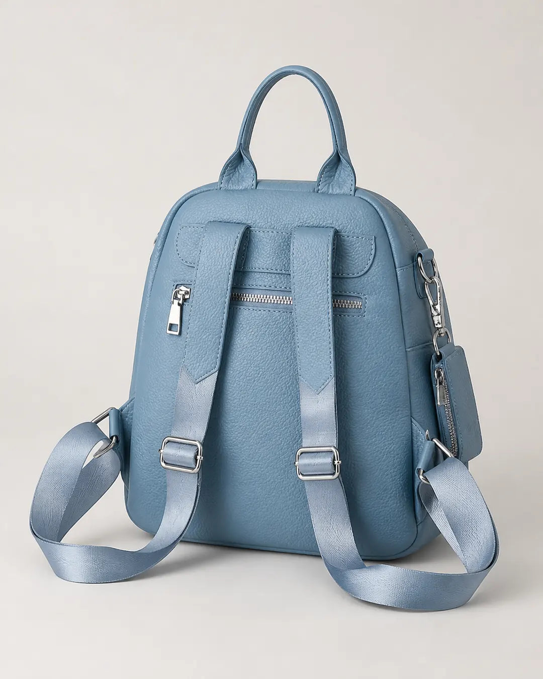 Mochila feminina de couro azul Serelle em vista traseira, com alças ajustáveis, bolso traseiro com zíper e acabamento texturizado.
