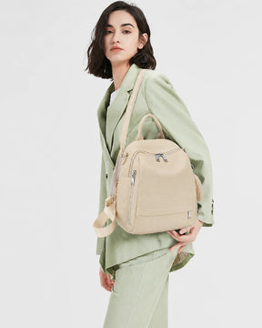 Mulher usando a mochila feminina de couro bege Serelle no ombro, destacando o tamanho, o caimento e o visual elegante da peça.

