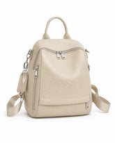 Mochila feminina de couro bege Serelle em vista frontal angulada, evidenciando os bolsos externos, os zíperes metálicos e o formato estruturado.