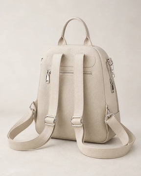 Mochila feminina de couro bege Serelle em vista traseira, com alças ajustáveis, bolso traseiro com zíper e acabamento em couro texturizado.
