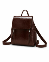 Mochila feminina de couro café Corinne em vista frontal sobre fundo claro, com aba superior e bolsos frontais com zíper.