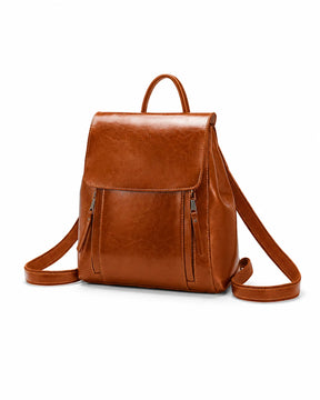 Mochila feminina de couro marrom Corinne em vista frontal sobre fundo claro, com aba superior e bolsos frontais com zíper.