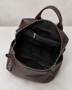 Mochila feminina de couro marrom Lorien aberta, exibindo o interior espaçoso com compartimentos internos e bolso com zíper para melhor organização.
