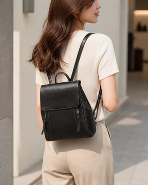 Mulher usando a mochila feminina de couro preta Corinne nas costas, destacando caimento, tamanho e estilo casual elegante.

Imagem 6