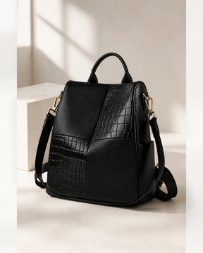 Mochila feminina de couro preta Elvienne em estúdio claro, com combinação de texturas e alças ajustáveis.
