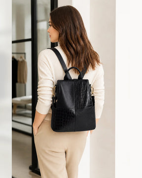 Mulher usando a mochila feminina de couro preta Elvienne nas costas, destacando tamanho, caimento e estilo no uso diário.