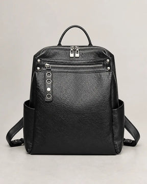 Mochila feminina de couro preta Lorien em vista frontal sobre fundo neutro, destacando o acabamento, os bolsos laterais e o fechamento com zíper.
