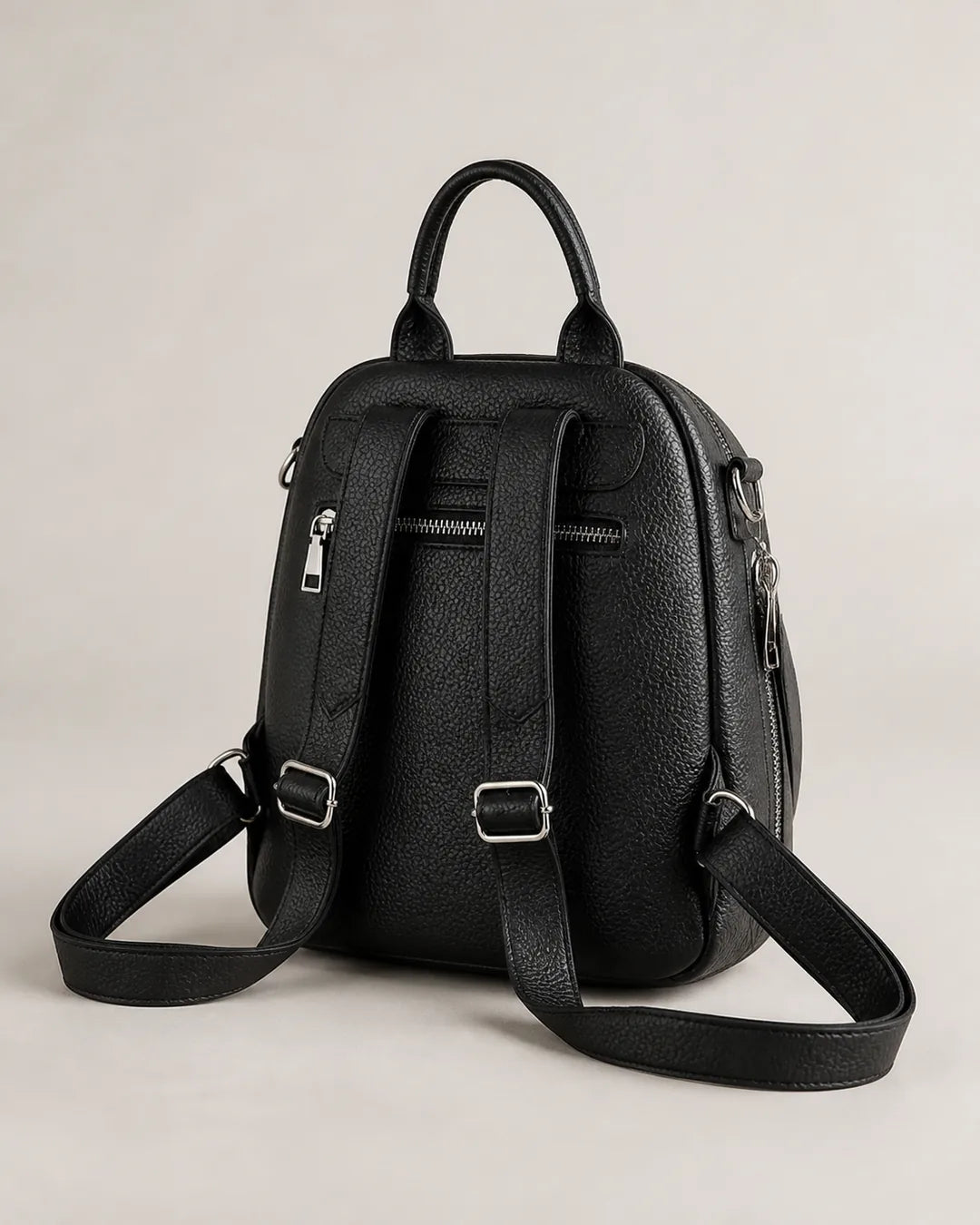 Mochila feminina de couro preta Serelle em vista traseira, com alças ajustáveis, bolso traseiro com zíper e acabamento sofisticado.